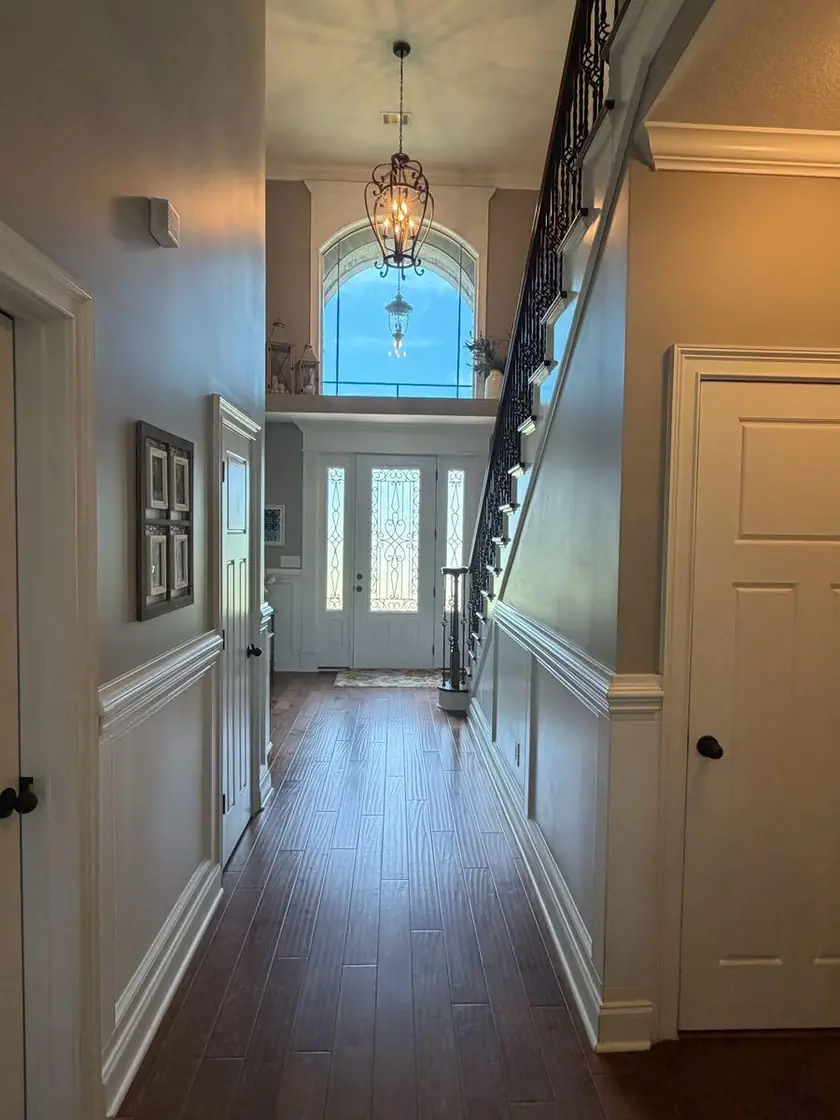 An entry hall with a staircase and an arched window over the front door