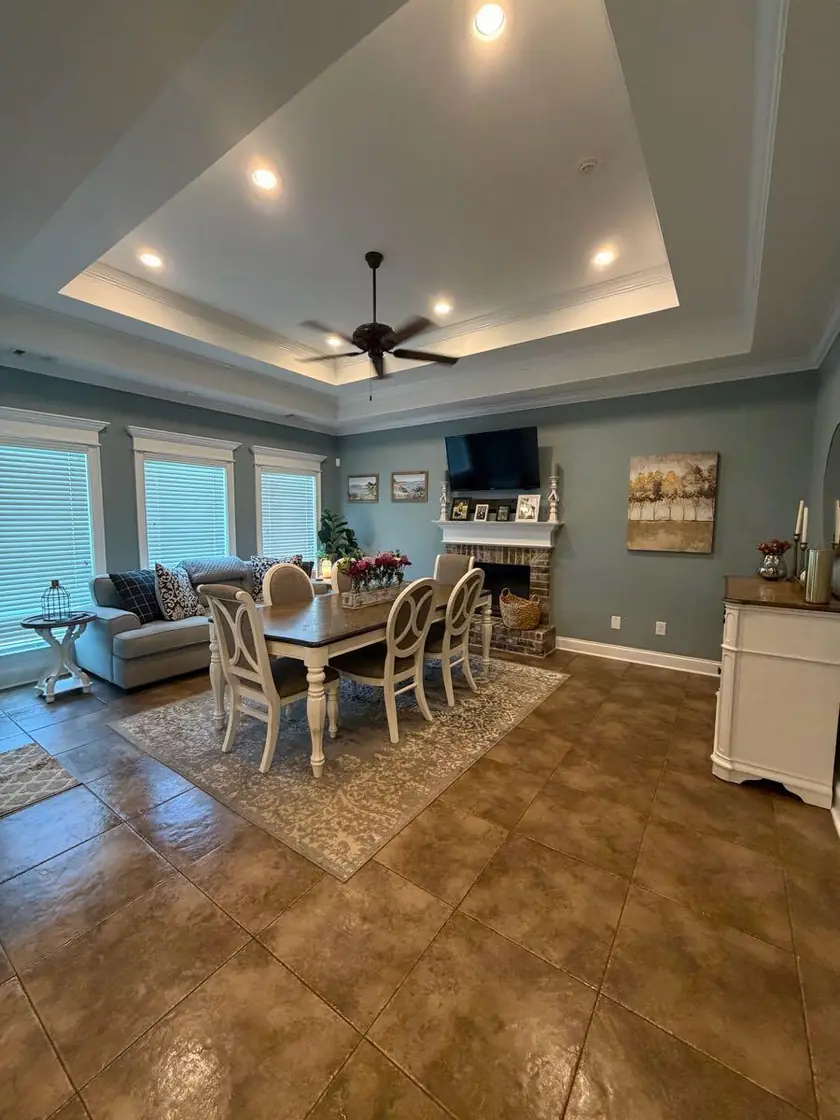 An open plan dining room and living room under a tray ceiling