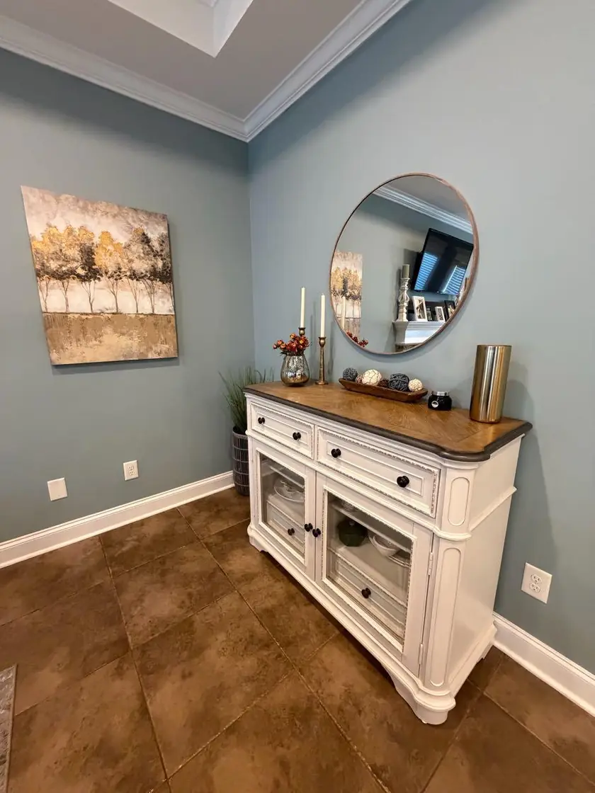 An entry console table with a round mirror above it